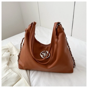 Close-up of caramel leather hobo bag with silver star emblem and chain detail