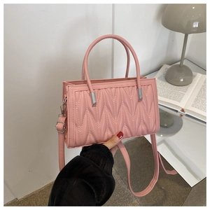 Detailed view of pink pleated wave-quilted PU leather handbag with detachable strap