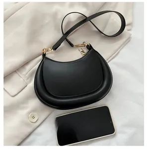 Detailed view of black crescent bag with gold zipper and adjustable shoulder strap