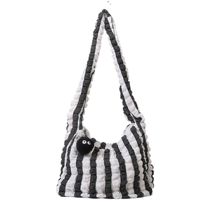 Fashionable black and white vertical stripe tote bag with textured popcorn fabric and charm