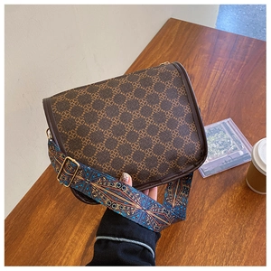 Détail du sac bandoulière rétro marron à motif trèfle et large sangle tissée bohème