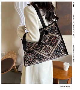 Detailed texture of ethnic knit tote bag with colorful geometric patterns and black strap
