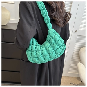 Détail du sac matelassé vert en nylon léger avec une bandoulière épaisse et confortable