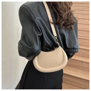 Detail showing smooth light beige leather moon bag with padded edges and sleek metal zipper