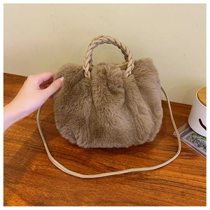 Detail of brown plush cloud bag showing woven handle and soft faux fur texture