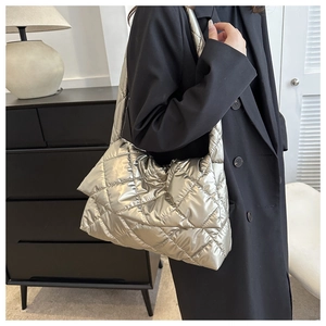 Detailed view of silver quilted down shoulder bag with luxury metallic finish