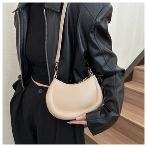 Detail of beige crescent shoulder bag with smooth leather finish and gold hardware
