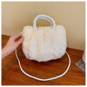Close-up of white plush crossbody bag with soft faux fur texture and woven handles