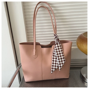 Close-up of pink PU leather tote bag with checkered scarf detail on handle