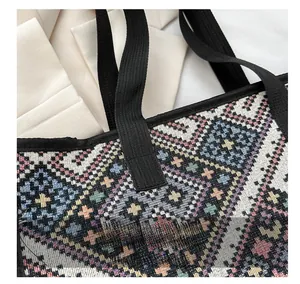 Detail showing reinforced stitching and geometric woven fabric on the canvas tote handle