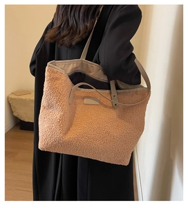 Fashionable oversized camel faux fur tote bag styled with a sleek black autumn coat