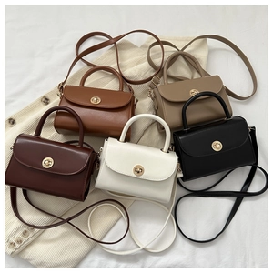 Flat lay detail showing a collection of retro square crossbody bags in five classic colors