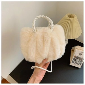 Detail of off-white plush cloud bag showing soft faux fur texture and woven handle