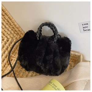 Detail of black faux fur cloud bag showing woven leather handle and soft plush texture