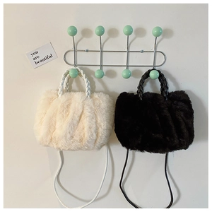 Detail of plush faux fur cloud bags in black and white with woven handles and straps
