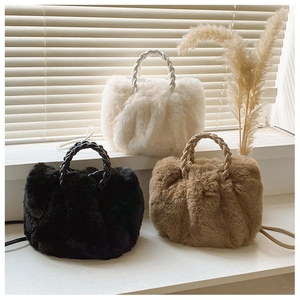 Detailed view of plush handbags with braided handles in white, black, and brown faux fur