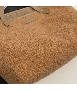 Detail of camel plush tote bag with reinforced faux leather handles and rivet accents