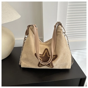 Détail du sac cabas en suédine beige avec écusson étoile en peluche marron et chaîne