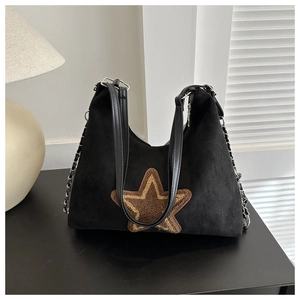 Détail du sac hobo en daim vintage avec écusson étoile et bandoulière en chaîne