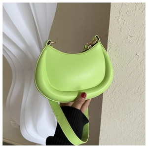 Detail of a bright green half-moon hobo bag showing smooth faux leather and modern curves