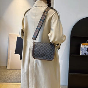 Sac bandoulière vintage monogramme avec large sangle ethnique sur trench-coat
