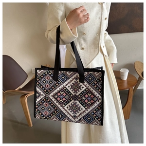 Close-up of geometric ethnic embroidery on a large capacity tote bag with black strap