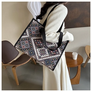 Ethnic style woven canvas tote bag with geometric patterns shown on a model