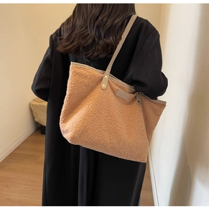 Detailed side view of the brown plush tote bag with grey PU handle and rivet details