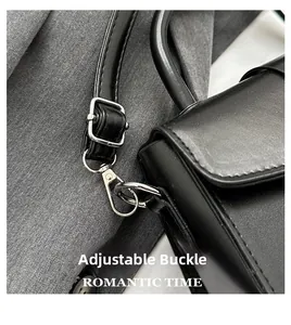 Detail of adjustable silver buckle and spring hook on black leather shoulder bag