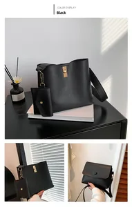 Detail view of large black textured leather bucket bag with golden buckle and coin purse
