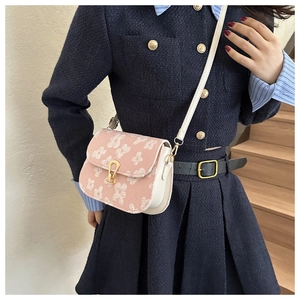 Detail of pink floral embroidery on a mini square crossbody bag with gold buckle clasp