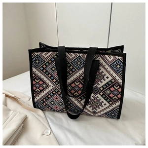 Detail of colorful geometric jacquard weaving and black straps on a large canvas tote bag