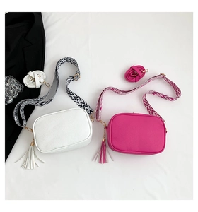 Flat lay of small crossbody bags in white and rose red with textured PU leather finish