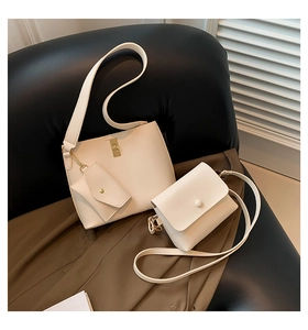 Detailed set of beige bucket bag and crossbody small square bag on black leather background