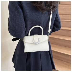 Back view of model wearing white leather crossbody bag with silver crescent buckle
