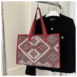 Detailed shot of ethnic geometric pattern canvas tote bag with red webbing handles