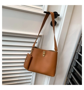 Detail view of brown PU leather bucket bag featuring gold clasp and hanging coin purse