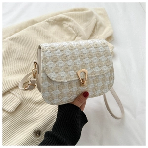 Close-up of quilted tweed texture on mini crossbody bag with golden metal horsebit lock