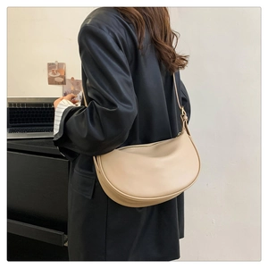 Detail of adjustable strap and golden hardware on beige minimalist PU hobo bag