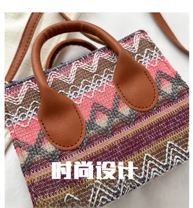 Detail of colorful woven shoulder bag featuring bohemian patterns and leather handles