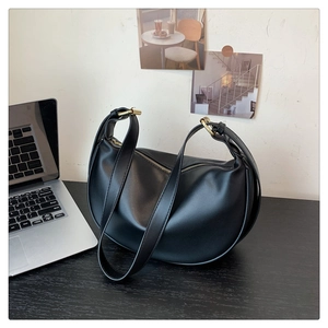 Detail view of a black soft PU leather crescent bag featuring refined gold metal hardware