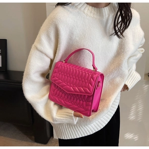 Detail van roze gewatteerde leren crossbodytas met elegante V-vormige flapsluiting