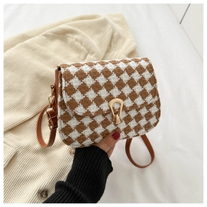 Detail showing the brown checkered tweed fabric and elegant gold U-shaped buckle on small bag