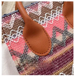 Detail of ethnic embroidered woven bag showing premium stitching and leather strap joint