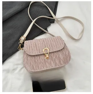 Detail of light pink pleated crossbody bag with a gold teardrop-shaped metal lock