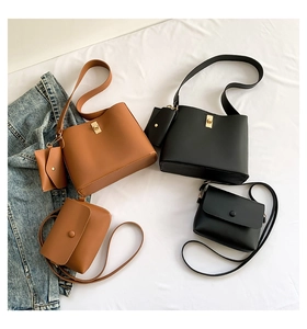 Detail of minimalist leather bucket and crossbody bags in dark brown and black colors