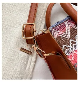 Detailed view of golden hardware buckle and adjustable leather strap on ethnic bag