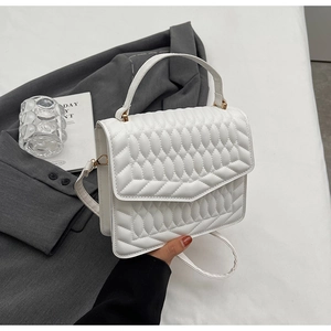 Detailweergave van witte gewatteerde tas van imitatieleer met geometrische patronen