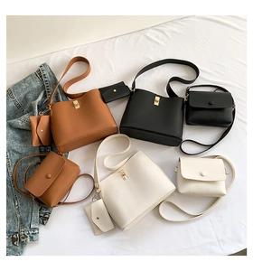 Various leather crossbody bags and small pouches in black, brown, and white with gold hardware