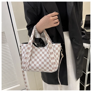 Detail of vintage checkerboard bucket bag featuring white and brown leather texture